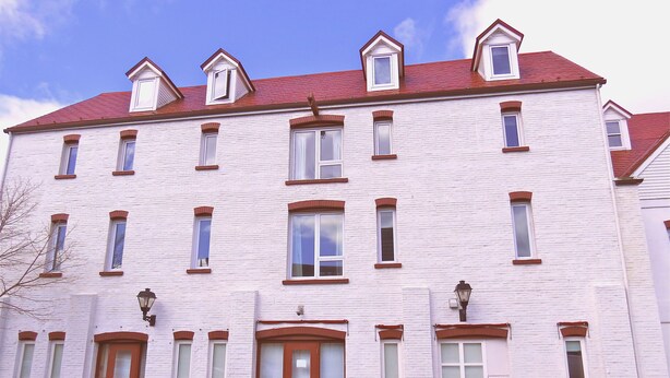 A multi-story building with a symmetrical facade, large windows, and a central entrance with a glass door. - The Murray Premises Hotel (St. John's)