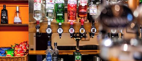 A bar area with multiple liquor dispensers and a selection of bottled spirits.