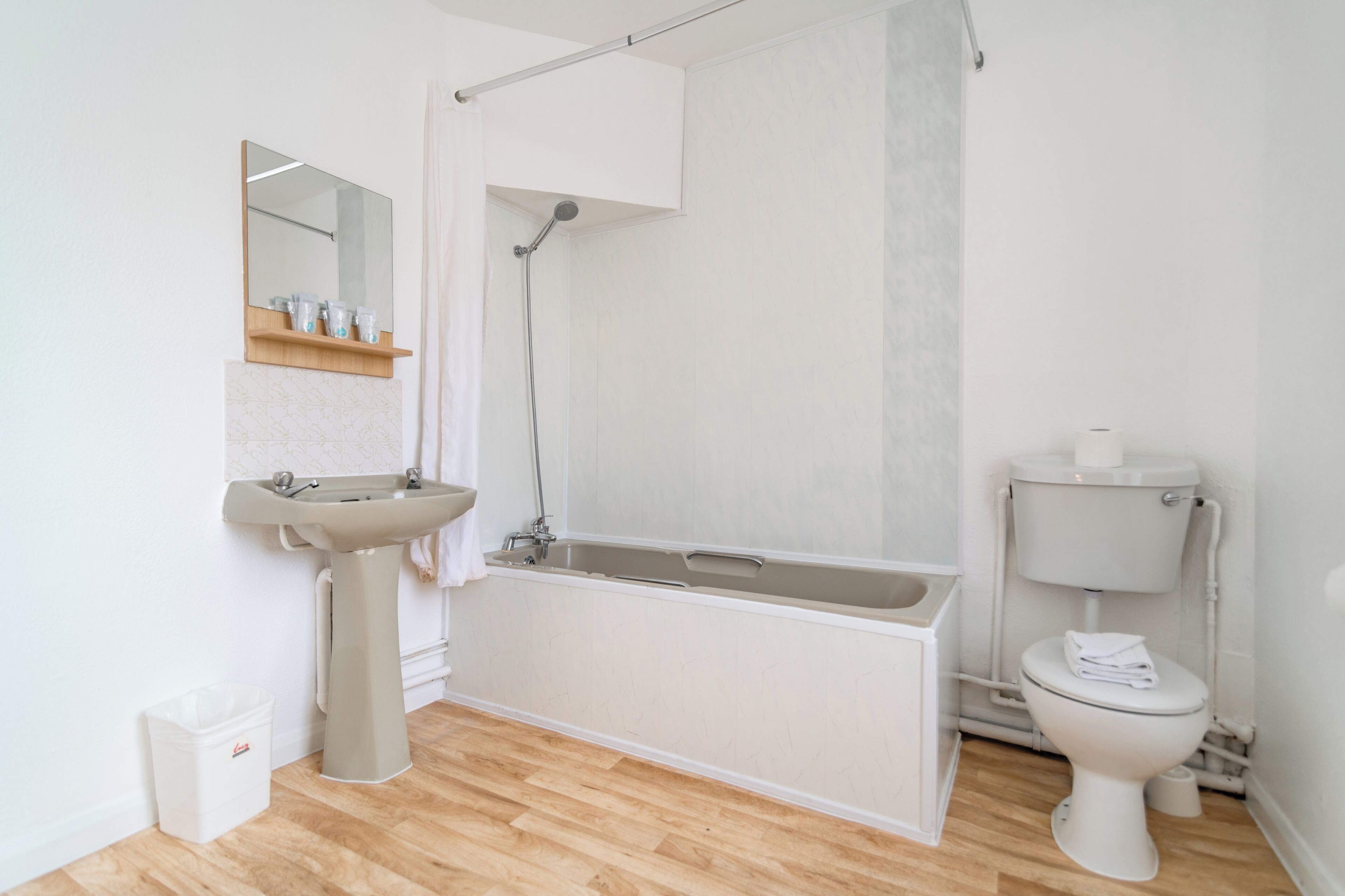 A bathroom with a sink, bathtub, toilet, and a shower curtain.