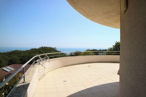 A balcony with a curved railing overlooking a body of water and greenery. - Park Hotel Bellevue (Golden Sands)