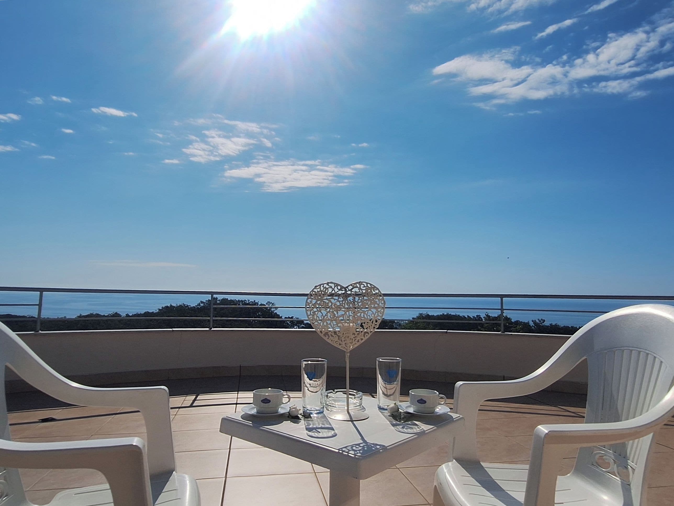 Una terraza con una mesa dispuesta para dos, con vistas panorámicas.