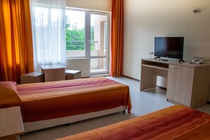 A hotel room with two beds, a desk with a television, and a balcony with orange curtains. - Park Hotel Bellevue (Golden Sands)
