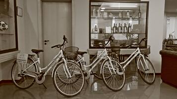 Deux vélos sont garés dans un couloir, avec une vitrine en arrière-plan.