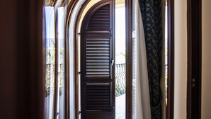 Un arco de entrada con una puerta de madera oscura y vistas a un balcón con barandilla.