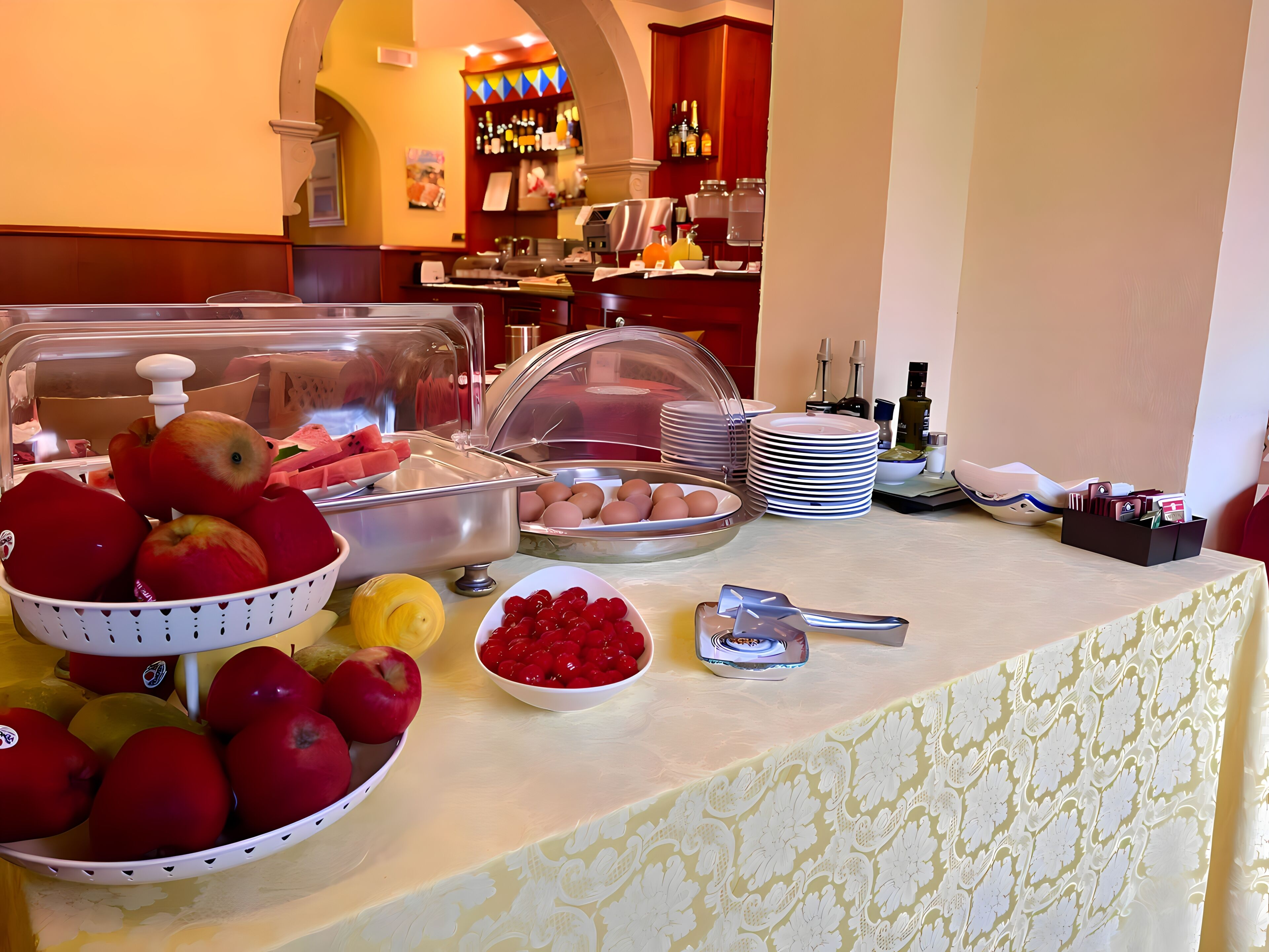 Una mesa de buffet con diversas frutas, huevos y aderezos.