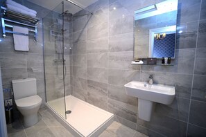 Tweepersoonskamer | Badkamer | Een bad/douchecombinatie, een haardroger, handdoeken