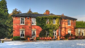 A large brick building with a covered patio area and outdoor seating.