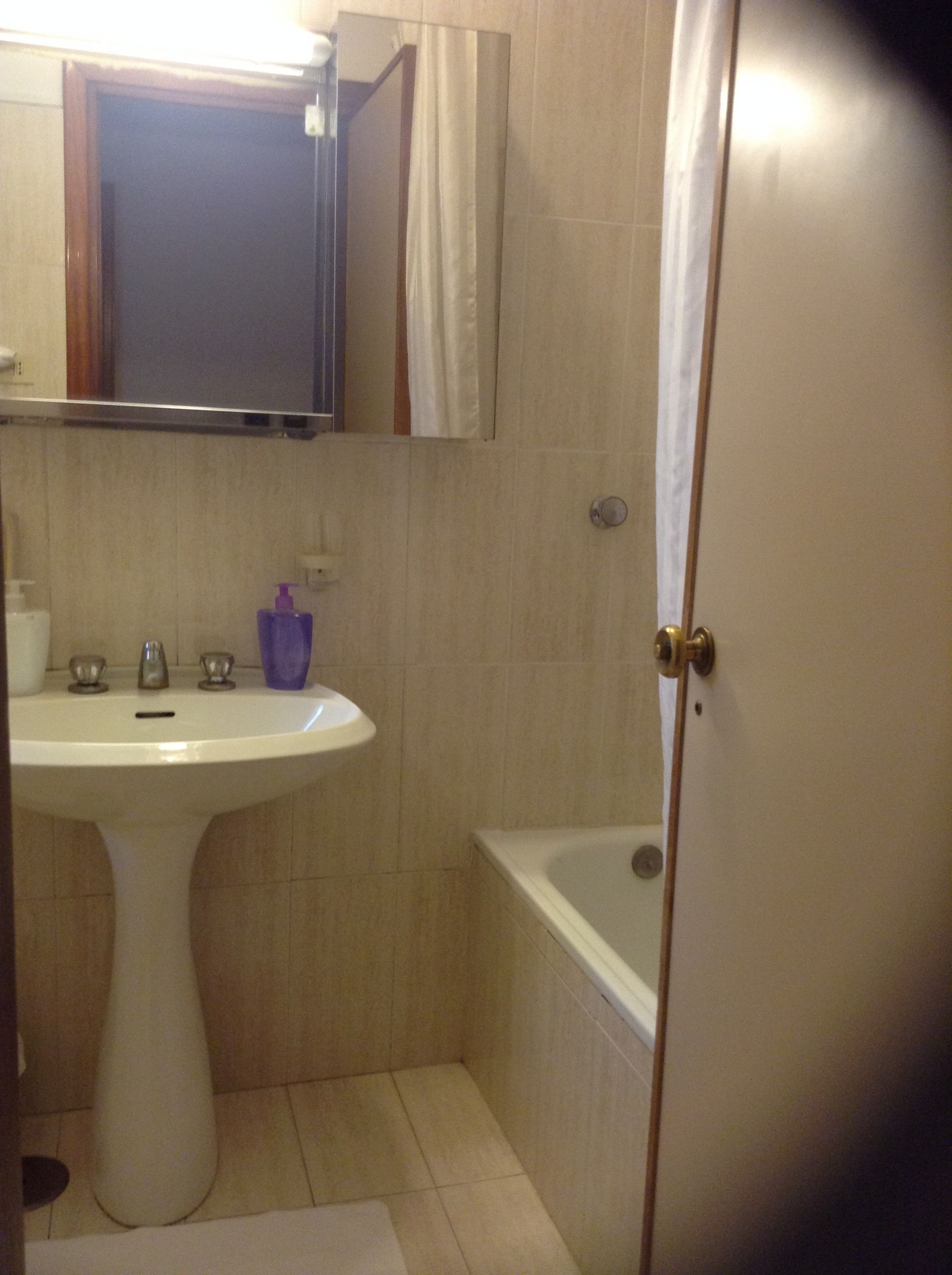 Une salle de bain avec un lavabo, un miroir et une baignoire.