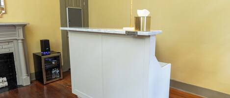 A reception desk with a 'No Cash Accepted' sign, a white marble fireplace, and a small trash bin.