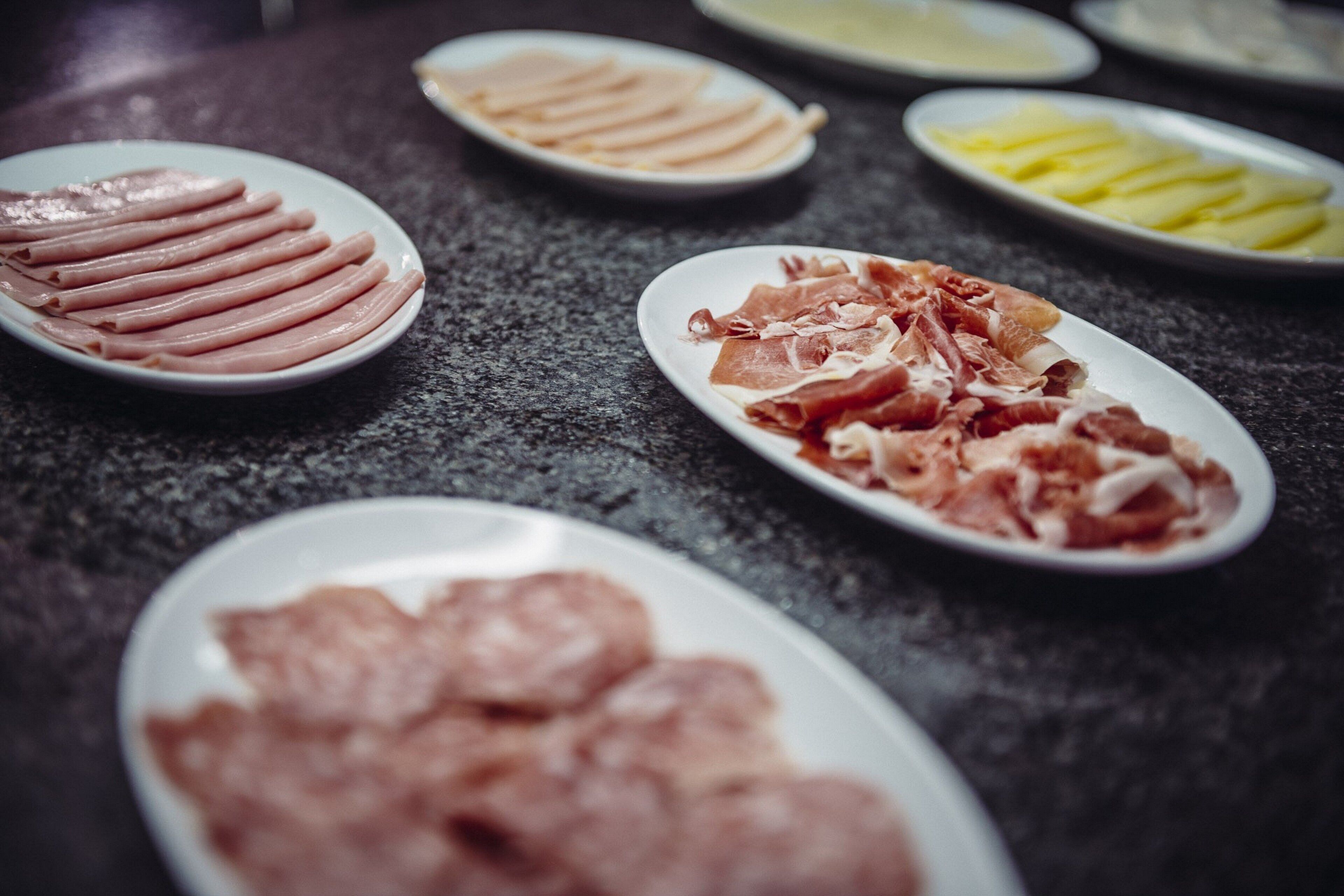 A table with various types of meat arranged on plates.