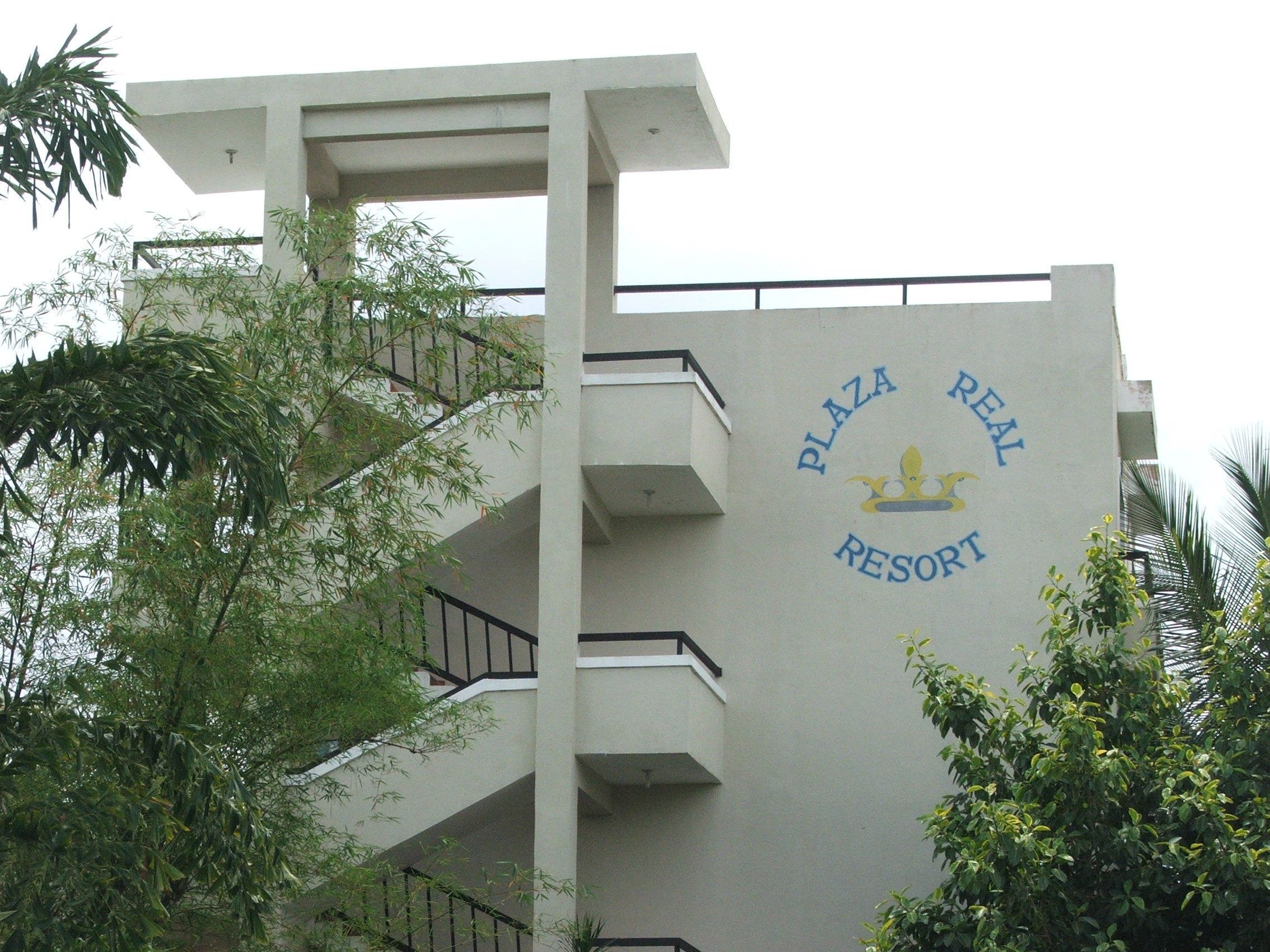 A building with a sign reading "Plaza Real Resort".