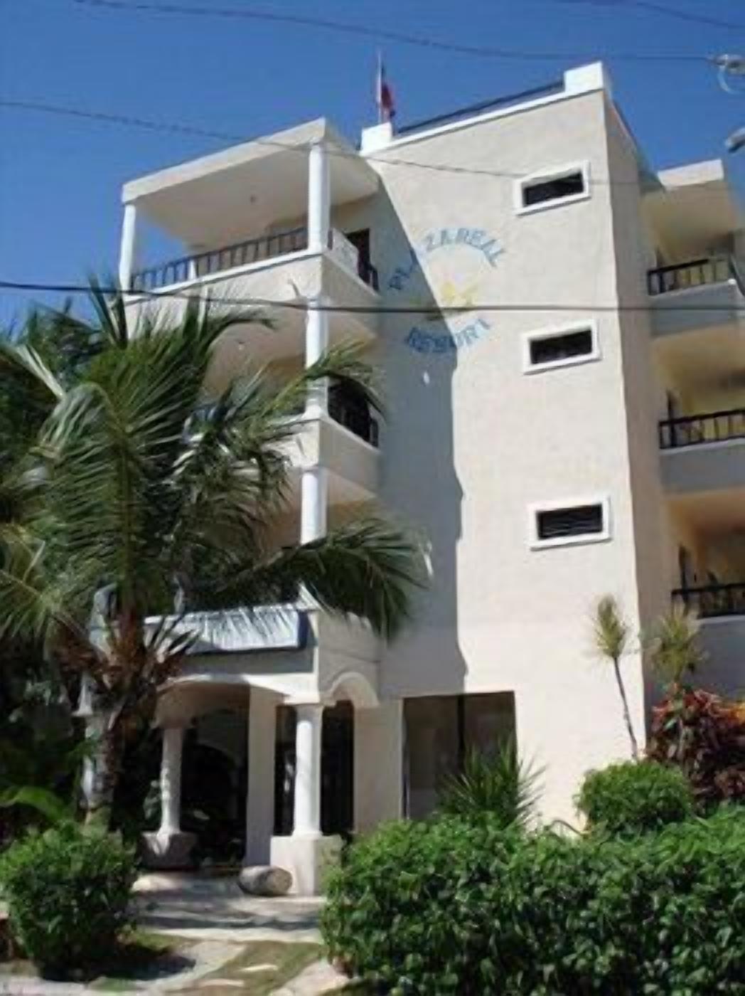Un edificio de varios pisos con balcones, una bandera y un cartel que dice "Hotel".