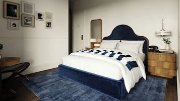 Een slaapkamer met een bed, een bureau, een stoel, een nachtkastje, een spiegel en lijstjes met foto's aan de muur.