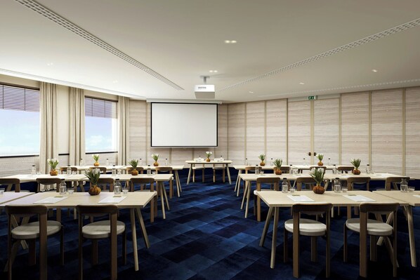 A conference room with a large screen, multiple tables, chairs, and a blue carpet. - Jadran, Rijeka, a Tribute Portfolio Hotel (Rijeka)