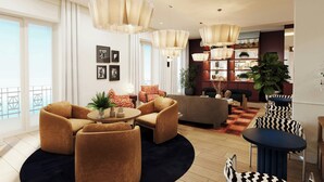 A modern living room with a sofa set, a coffee table, and a dining area with chairs. There are large windows and a view of the outdoors.