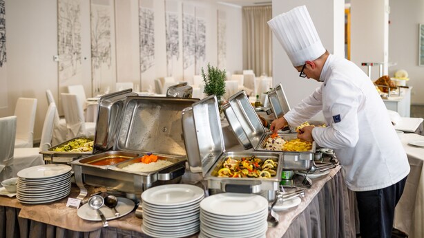 Un buffet proposant différents plats, avec notamment du riz, des légumes et des pâtes.