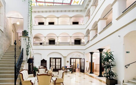 A multi-level atrium with a staircase, seating area, and a restaurant named 'L'Olive.'