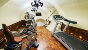 Un gimnasio con cintas de correr, elípticas y equipos de pesas.
