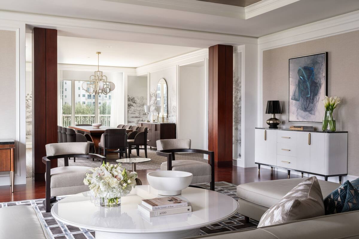 A modern living room with a round coffee table, a sofa, and a dining area with chairs and a table.