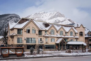 A multi-story hotel with a mountain backdrop, featuring a restaurant and a sign for 'Irwin's Mountain Inn.'