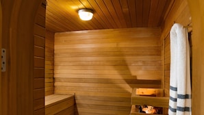 Eine Sauna mit Holzbänken und einer Bank mit Handtuch.