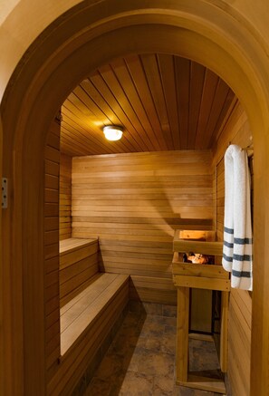 Een sauna met houten banken en een bankje met een handdoek.