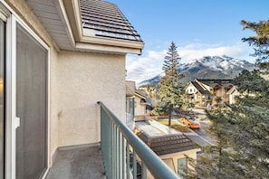 Un edificio residencial con balcón que da a una montaña nevada.