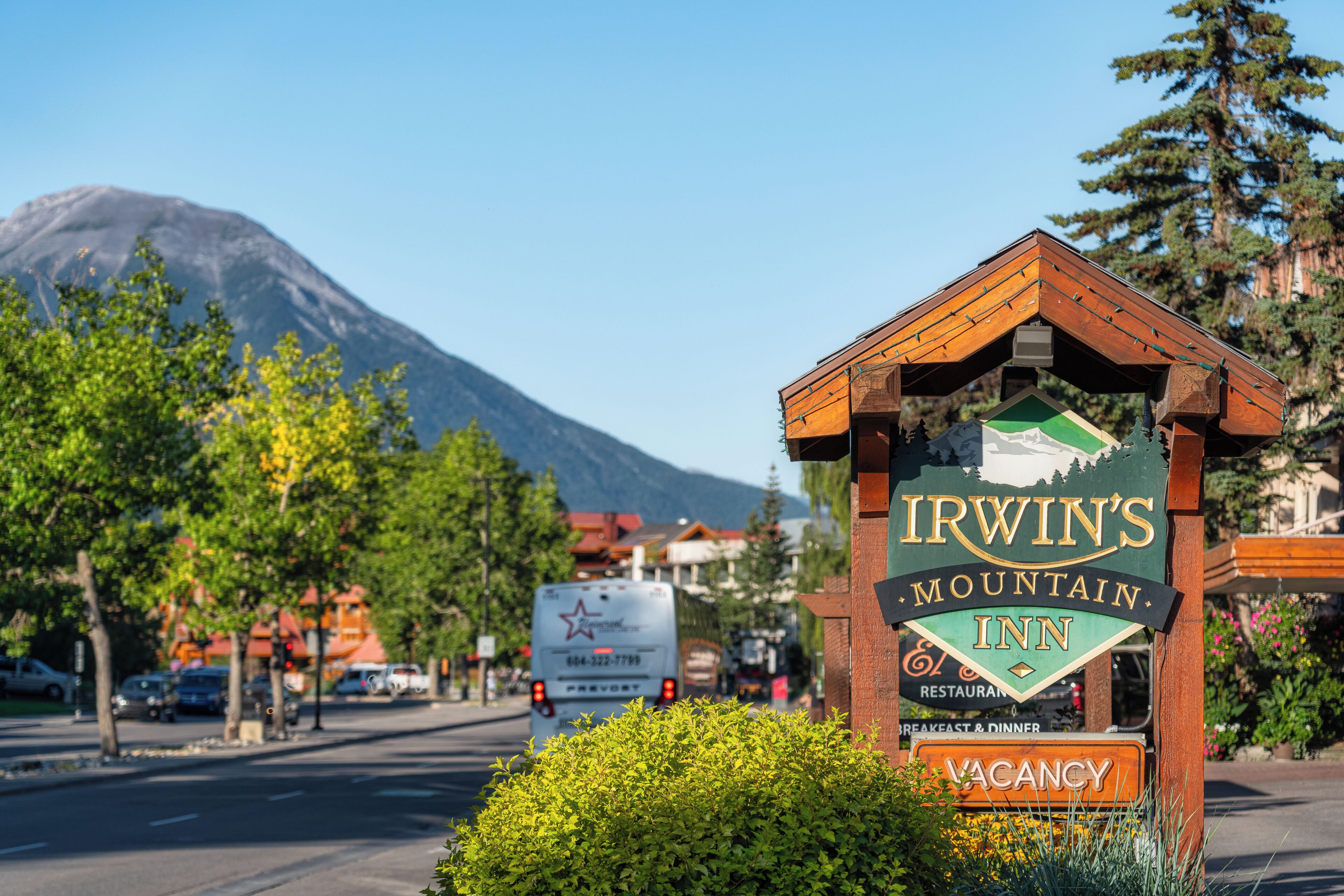 A sign for Irwin's Mountain Inn with a mountain in the background.