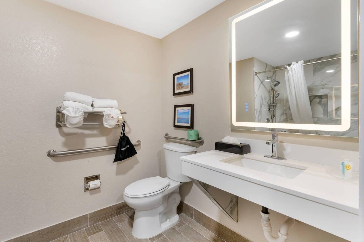Un baño con inodoro, lavabo y espejo.
