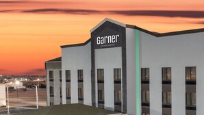 Un hotel moderno con techo plano, una entrada destacada y un letrero que dice "Garner".