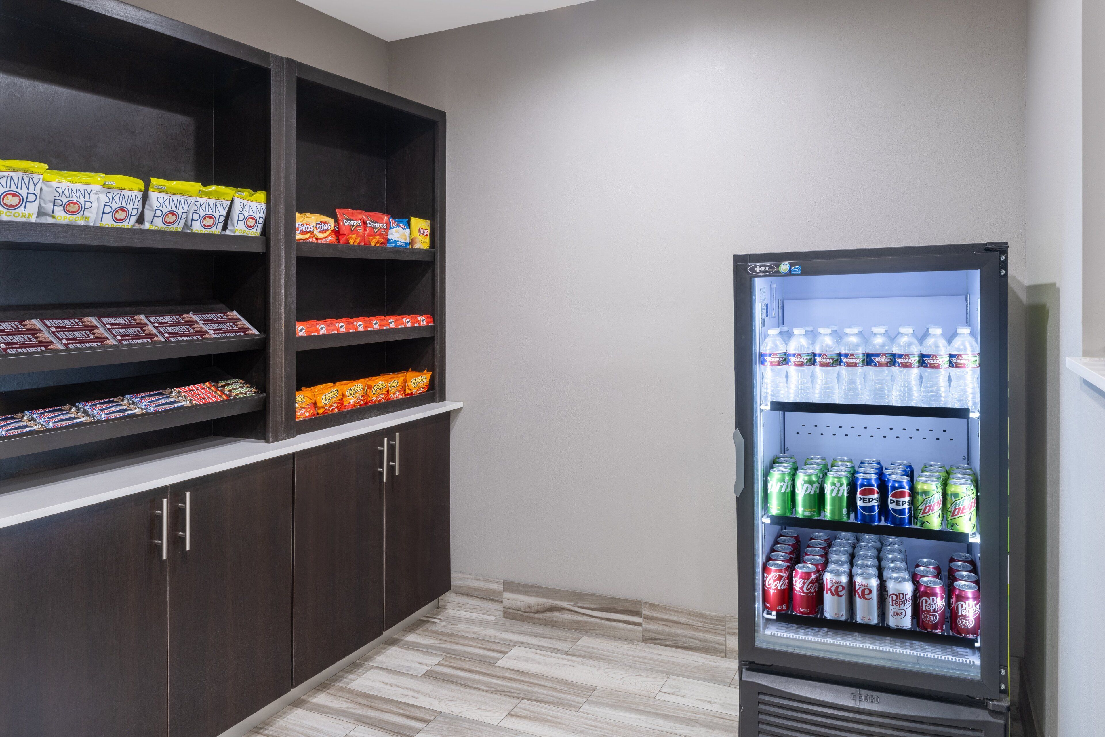 Máquina expendedora llena de aperitivos y bebidas, como papas fritas, caramelos y refrescos.