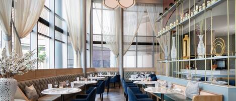 A restaurant with a long counter, booths, and a bar area.