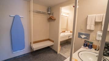 A bathroom with a shower, a sink, and a mirror.