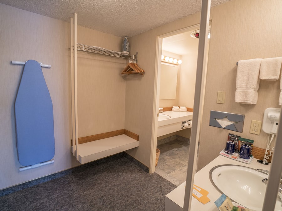 A bathroom with a shower, a sink, and a mirror.