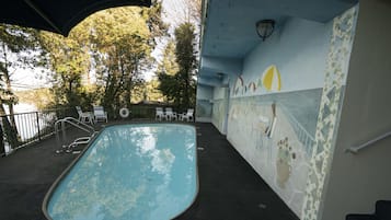 Una piscina al aire libre de temporada, sombrillas