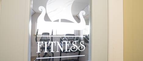 Una ventana con el logotipo de un centro de acondicionamiento físico y la palabra 'FITNESS' en letras negritas.