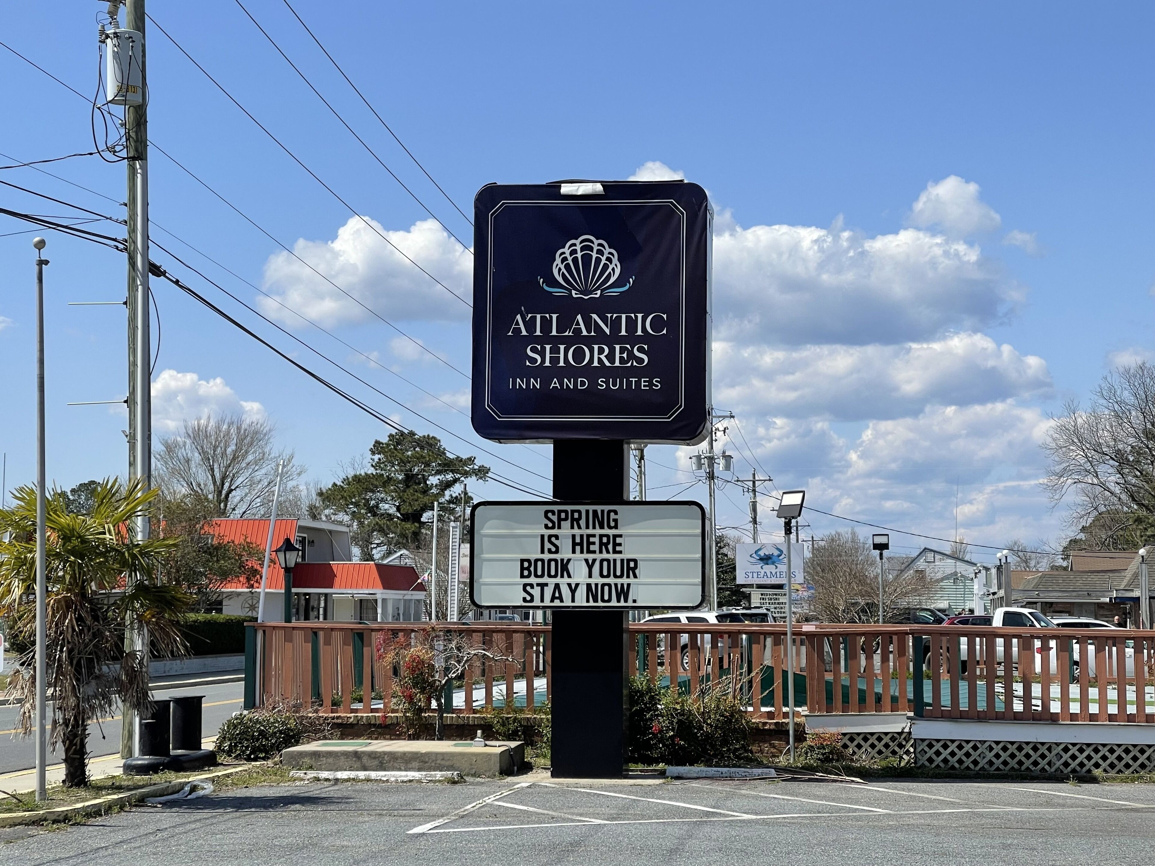 A sign for Atlantic Shores Inn and Suites advertising spring bookings.