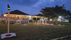 A house with a covered patio area, a lawn, and a birdhouse. - Atlantic Shores Inn and Suites (Chincoteague)