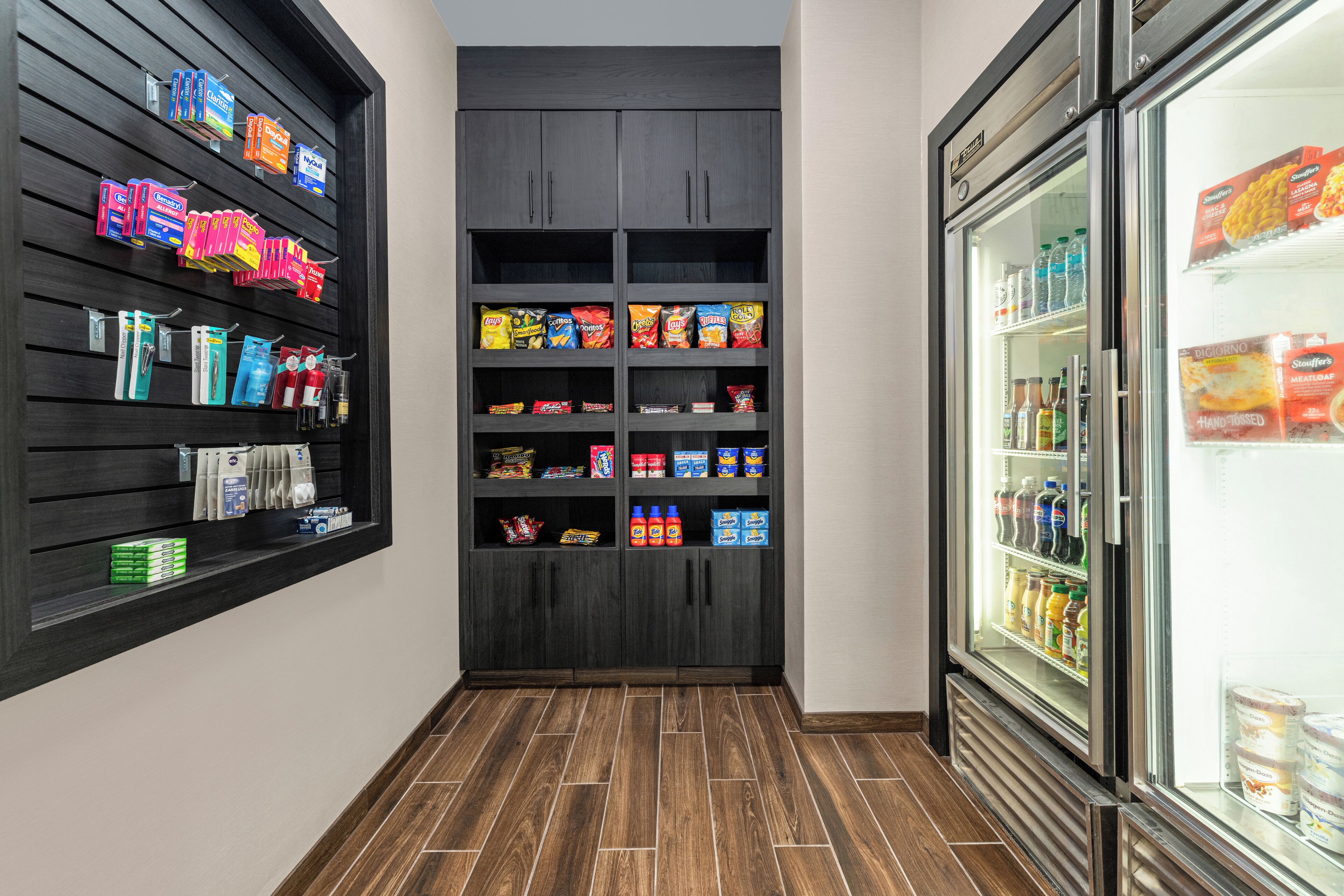 A narrow hallway with a snack shelf, a beverage refrigerator, and a storage cabinet.