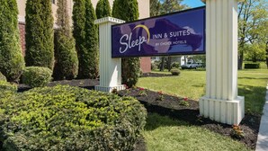 A sign for Sleep Inn & Suites by Choice Hotel with a landscaped garden in front. - Sleep Inn & Suites Gettysburg (Gettysburg)