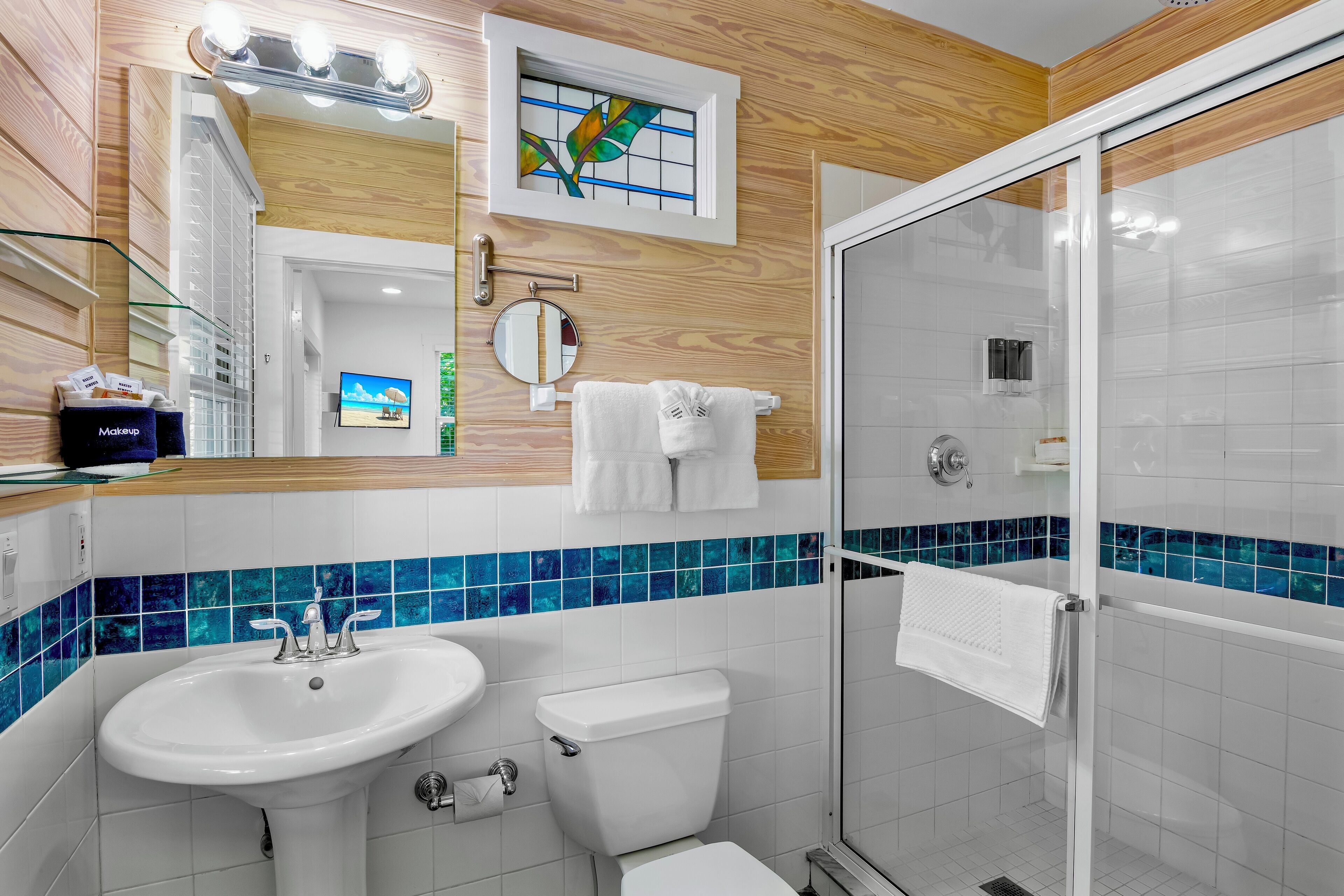 Ein modernes Badezimmer mit Duschkabine aus Glas, einem weißen Waschbecken und einer Toilette.
