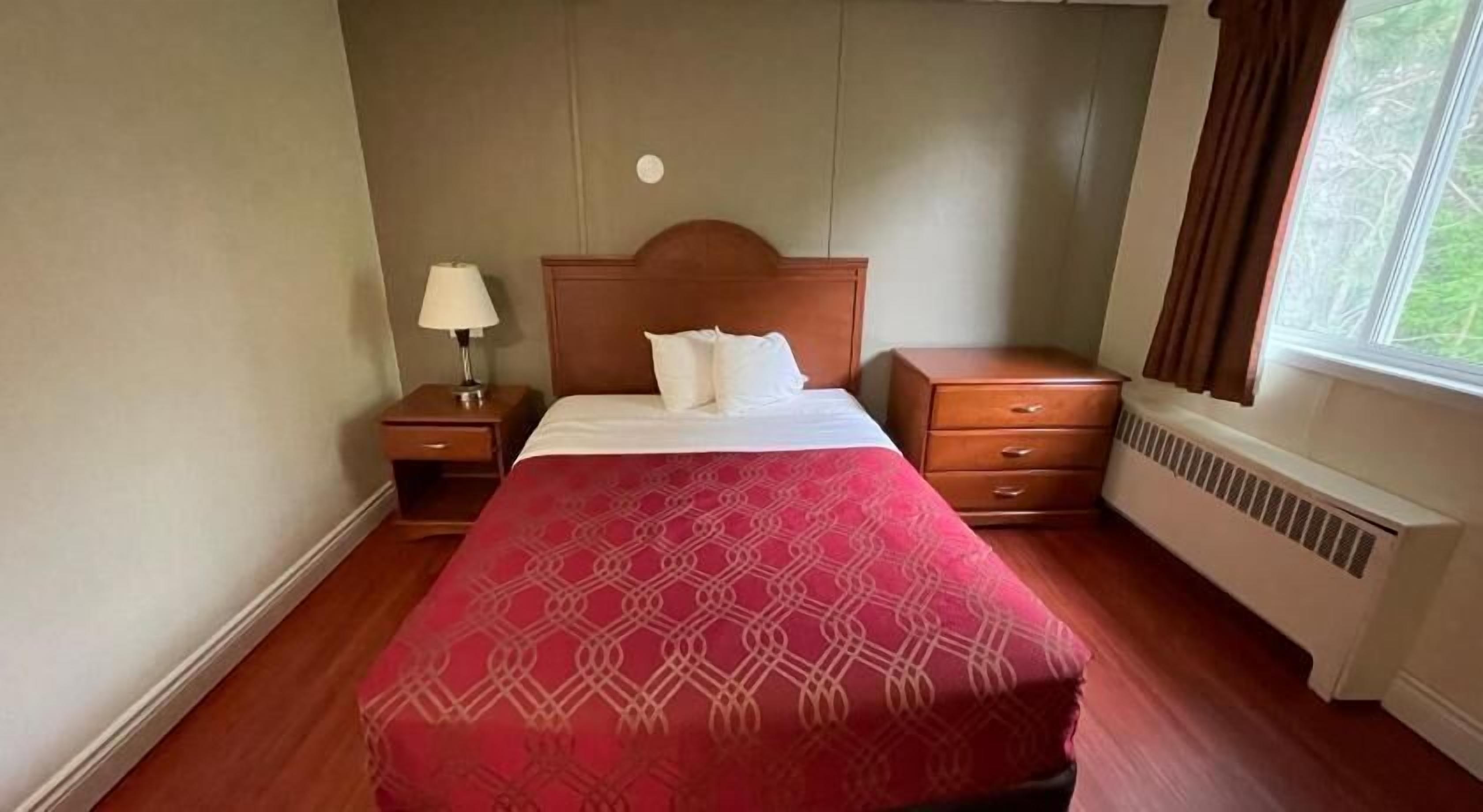 Escritorio, tabla de planchar con plancha, ropa de cama y despertador 