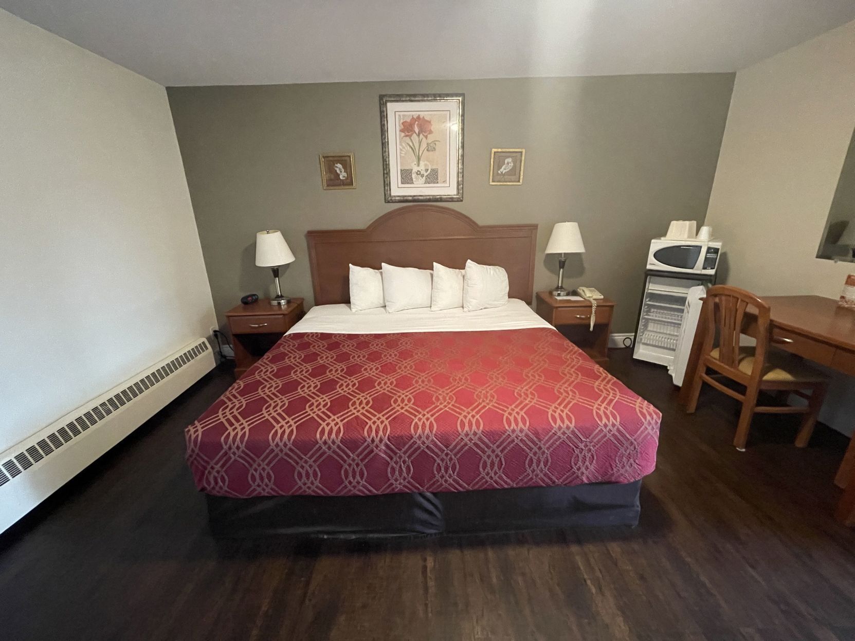 Escritorio, tabla de planchar con plancha, ropa de cama y despertador 