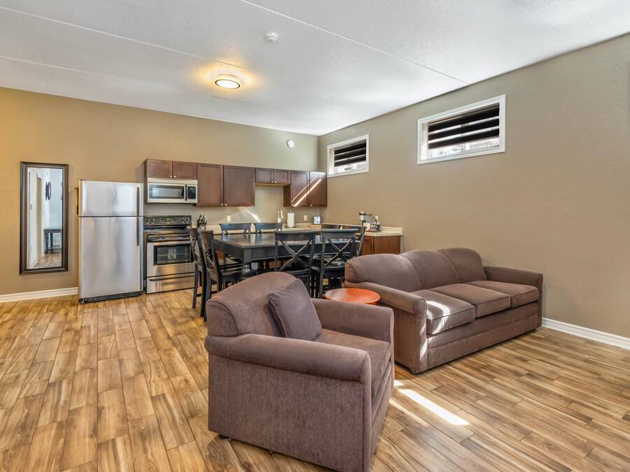 Um espaço compacto com cozinha compacta, uma mesa de jantar e dois sofás.