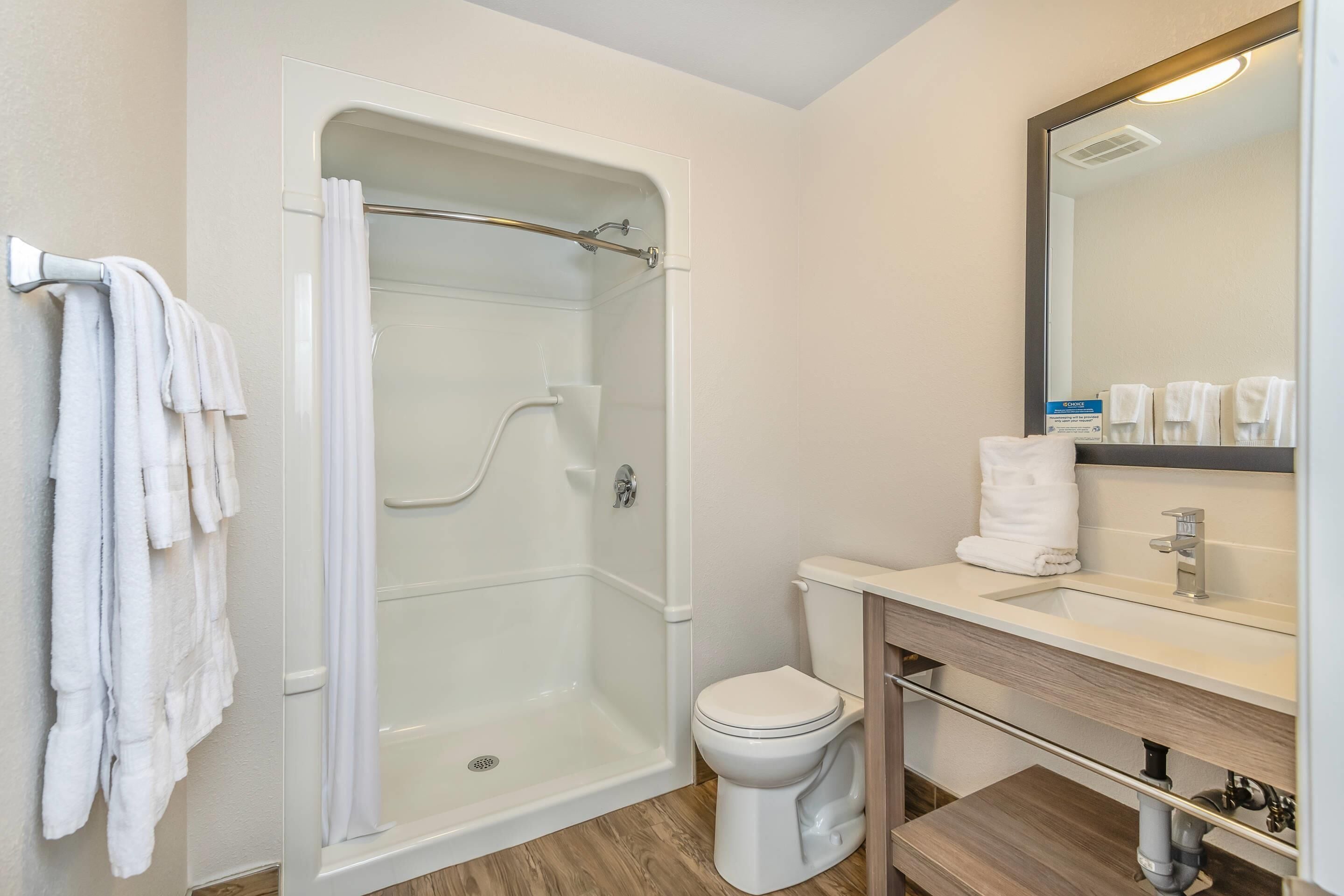 A bathroom with a shower, toilet, and sink.