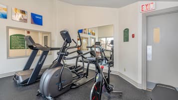 Un gimnasio con cintas de correr, elípticas y bicicletas estáticas.