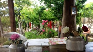A wooden table with two metal teapots and a small vase with flowers. - Hotel Casas Alberto (San Miguel de Abona)