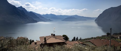 A lake surrounded by mountains with terraced houses in the foreground.