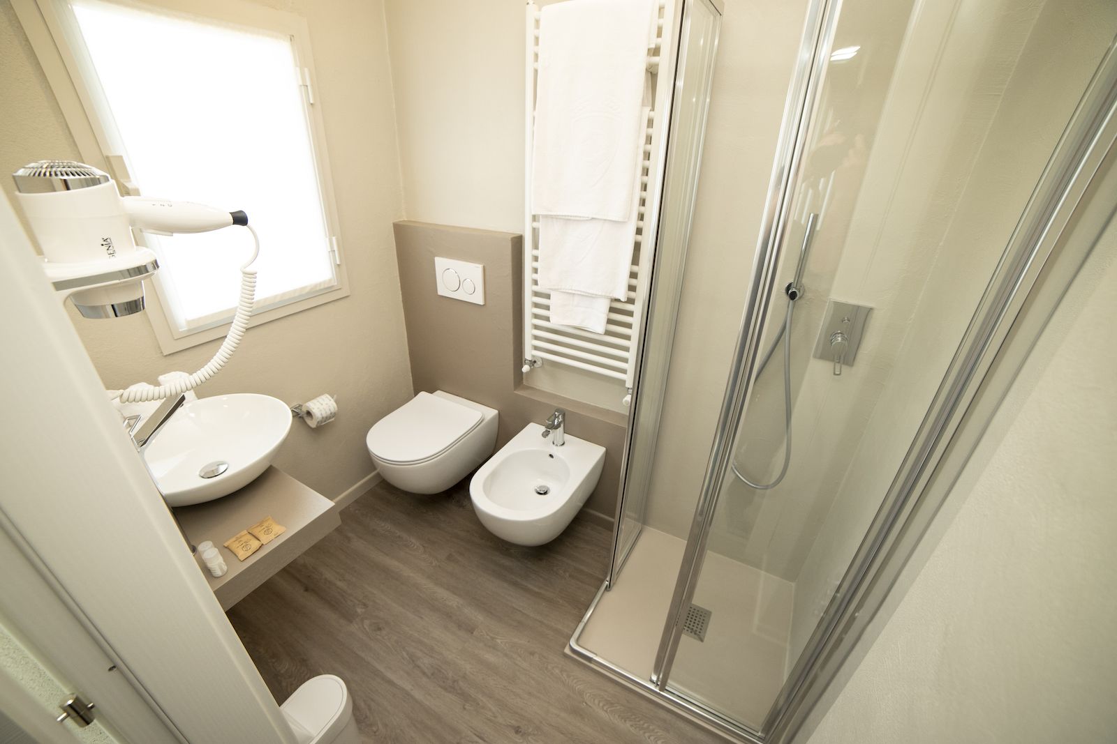 A modern bathroom with a toilet, bidet, and shower.