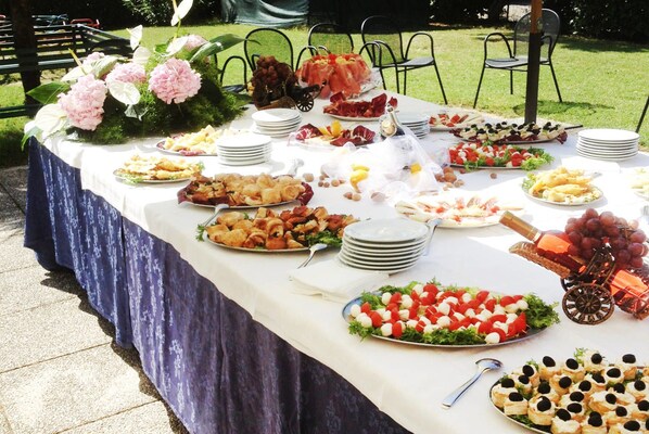 A buffet table with various food items and a decorative centerpiece.